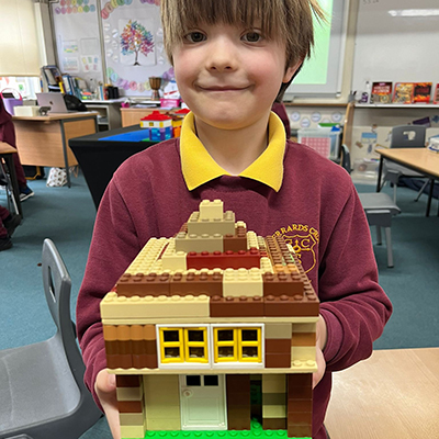 KS1 Boy showing off LEGO Tudor House